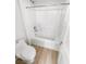Bright bathroom features a white tile shower-tub combo and wood-look flooring at 6537 Ditmars St, Las Vegas, NV 89166
