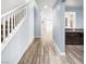 Hallway with staircase and view of the kitchen, featuring wood-look floors at 6537 Ditmars St, Las Vegas, NV 89166