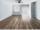Expansive living room with light walls, hardwood floors, ceiling fan, and sliding door at 6537 Ditmars St, Las Vegas, NV 89166