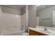 Bright bathroom features a bathtub with white tile surround and a wooden vanity with a large mirror at 6777 Wormwood Ln, Las Vegas, NV 89148