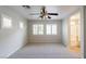 Bright bedroom featuring plush carpet, ceiling fan, and windows with white shutters at 6777 Wormwood Ln, Las Vegas, NV 89148