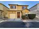 Two-story home with a two car garage, charming red front door, and manicured landscaping at 6777 Wormwood Ln, Las Vegas, NV 89148