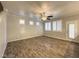Spacious living area with wood-style flooring, modern ceiling fan, and access to outdoor patio at 6777 Wormwood Ln, Las Vegas, NV 89148
