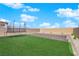 Backyard with manicured artificial grass, trampoline, brick retaining wall, and mountain views at 7128 Port Stephens St, North Las Vegas, NV 89084