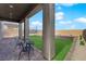 Covered patio with outdoor seating and a well-maintained artificial grass lawn at 7128 Port Stephens St, North Las Vegas, NV 89084