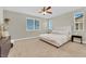 Bedroom with neutral walls and carpet features windows and a ceiling fan at 7128 Port Stephens St, North Las Vegas, NV 89084