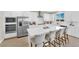 Modern kitchen featuring white cabinets, stainless steel appliances, and a large island with bar stool seating at 7128 Port Stephens St, North Las Vegas, NV 89084