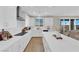 Bright kitchen with white cabinetry, stainless steel appliances, large island and sliding glass door access to backyard at 7128 Port Stephens St, North Las Vegas, NV 89084