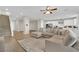 Bright, open living room and kitchen area featuring a large sectional, stairs and a seamless flow at 7128 Port Stephens St, North Las Vegas, NV 89084