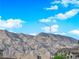 Scenic view of mountains with clear blue skies and puffy white clouds above rooftops at 7128 Port Stephens St, North Las Vegas, NV 89084