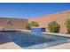 A well-maintained pool features a modern waterfall accent, surrounded by lush greenery and a brick privacy wall at 748 Dellenbaugh Ct, Las Vegas, NV 89178