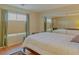 Bedroom featuring mirrored closet, wooden floors and ample natural light at 7751 Locke Haven Dr, Las Vegas, NV 89123
