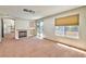Bright living room with carpeted floors, large window, fireplace and outdoor access to a balcony at 7751 Locke Haven Dr, Las Vegas, NV 89123