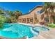 Inviting backyard oasis featuring a sparkling pool, spa, covered patio, and lush landscaping at 7751 Locke Haven Dr, Las Vegas, NV 89123