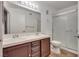Well-lit bathroom featuring double sinks, a framed mirror, and a glass-enclosed shower at 7950 W Flamingo Rd # 2065, Las Vegas, NV 89147
