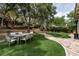 Lush backyard features green grass, a stone pathway, mature trees, and an outdoor dining area at 801 Aquitaine Ct, Las Vegas, NV 89145