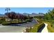 Gated community entrance with lush landscaping, mountain views, and sidewalks at 801 Aquitaine Ct, Las Vegas, NV 89145