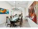 Elegant dining room features a modern chandelier, a glass table, and ample seating for large gatherings at 801 Aquitaine Ct, Las Vegas, NV 89145