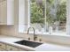 Bright kitchen featuring a stainless steel sink and a large window with a view of the outdoor greenery at 801 Aquitaine Ct, Las Vegas, NV 89145