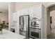 Bright kitchen showcasing stainless steel appliances, white cabinets, and easy access to living area at 801 Aquitaine Ct, Las Vegas, NV 89145