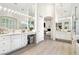 Luxurious main bathroom with double vanity, large mirrors, and wood-look floors at 801 Aquitaine Ct, Las Vegas, NV 89145