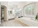 Elegant main bathroom featuring a soaking tub, glass shower, and vanity area with ample lighting at 801 Aquitaine Ct, Las Vegas, NV 89145