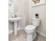 Stylish powder room with pedestal sink, modern toilet, decorative mirror, and light gray walls at 801 Aquitaine Ct, Las Vegas, NV 89145