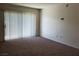 Bright living room featuring neutral carpet and sliding glass doors for ample natural light at 8070 W Russell Rd # 1028, Las Vegas, NV 89113