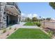 Beautiful backyard with manicured lawn, stone patio, and outdoor kitchen area at 8721 Robinson Ridge Dr, Las Vegas, NV 89117