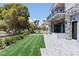 Beautifully landscaped backyard with stone patio, outdoor kitchen, lawn and view at 8721 Robinson Ridge Dr, Las Vegas, NV 89117