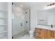 Modern bathroom featuring glass enclosed shower, marble countertops, and wood grain cabinets at 8721 Robinson Ridge Dr, Las Vegas, NV 89117