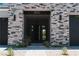 Covered entryway with a modern front door and exterior stone accents at 8721 Robinson Ridge Dr, Las Vegas, NV 89117