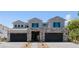 Striking two-story home featuring stone accents, a three-car garage, and desert landscaping at 8721 Robinson Ridge Dr, Las Vegas, NV 89117
