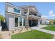 Two-story home with manicured backyard, stone accents, patio, and outdoor kitchen at 8721 Robinson Ridge Dr, Las Vegas, NV 89117
