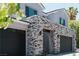 Close up of a gray house with dark garage doors and a stone wall at 8721 Robinson Ridge Dr, Las Vegas, NV 89117