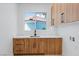 Convenient laundry room features counter space, wood cabinets and a backyard view at 8721 Robinson Ridge Dr, Las Vegas, NV 89117