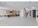 Spacious living room with modern kitchen, staircase, tile floors, and open-concept design at 8721 Robinson Ridge Dr, Las Vegas, NV 89117