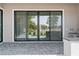 Covered outdoor patio with large glass sliding doors provides stunning view to landscaped backyard at 8721 Robinson Ridge Dr, Las Vegas, NV 89117