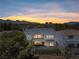 Two-story home with a balcony, stone accents, a small backyard with artificial lawn, and mountain views at 8721 Robinson Ridge Dr, Las Vegas, NV 89117