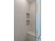Modern walk-in shower featuring neutral tile and dual built-in shower storage at 8721 Robinson Ridge Dr, Las Vegas, NV 89117