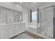This bright bathroom features double sinks, a separate shower, and a soaking tub at 8870 Sasquatch Run Ave, Las Vegas, NV 89166