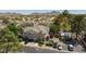 Aerial view of tan townhomes with gray roofs, green landscaping, small community space, and parked cars at 915 Graceful Moon Ave, Henderson, NV 89015