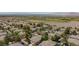 Aerial view of townhomes, with desert behind, many green trees and palm trees, and a sports field at 915 Graceful Moon Ave, Henderson, NV 89015