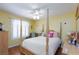 Comfortable yellow bedroom with a four-poster bed, bright lighting, and plantation shutters at 915 Graceful Moon Ave, Henderson, NV 89015