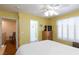 Bright and airy yellow bedroom with a four-poster bed, plantation shutters, and an ensuite bathroom at 915 Graceful Moon Ave, Henderson, NV 89015