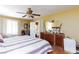Cozy bedroom with wood floors, a ceiling fan, and a view of the dresser, desk, and bathroom at 915 Graceful Moon Ave, Henderson, NV 89015