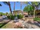 Community space includes a white pergola, BBQ pit, sidewalks, lush landscaping, and tall palm trees in the townhome community at 915 Graceful Moon Ave, Henderson, NV 89015