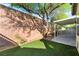 Private backyard with artificial turf, mature tree, and covered patio at 925 Crescent Falls St, Henderson, NV 89011