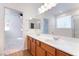 Bright bathroom with double sinks and an expansive mirror reflecting the adjacent bedroom at 925 Crescent Falls St, Henderson, NV 89011
