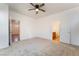 Spacious carpeted bedroom featuring a ceiling fan and access to an ensuite bathroom at 925 Crescent Falls St, Henderson, NV 89011